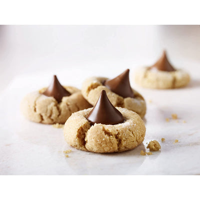 Four cookies with Hershey’s Kisses Milk Chocolate 306g on top.