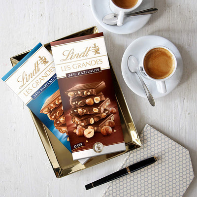 A tray with a cup of coffee and a Lindt Grand Hazelnut Dark Bar 150g.