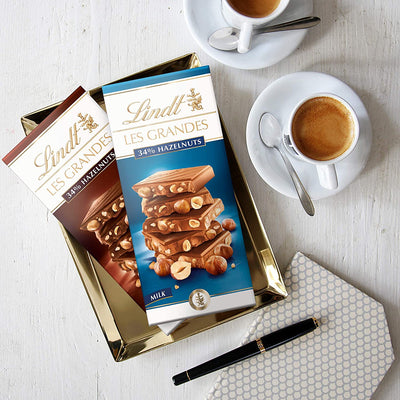 A tray with a cup of coffee and a box of Lindt Grand Hazelnut Milk Bar 150g chocolates.