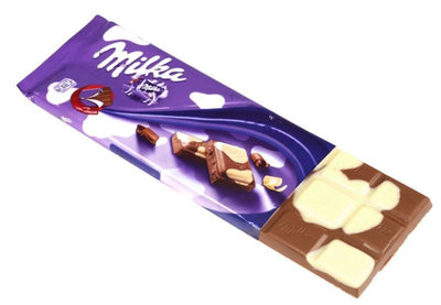An Milka Cowspot Bar 100g chocolate bar on a white background.