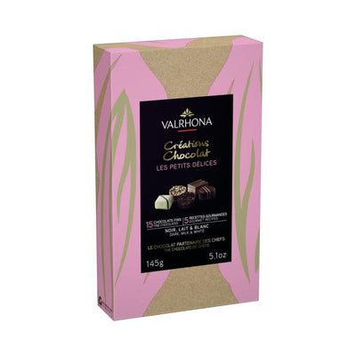 A Valrhona Petits Delices Milk, Dark & White 15pc Gift Box 145g with a pink background.