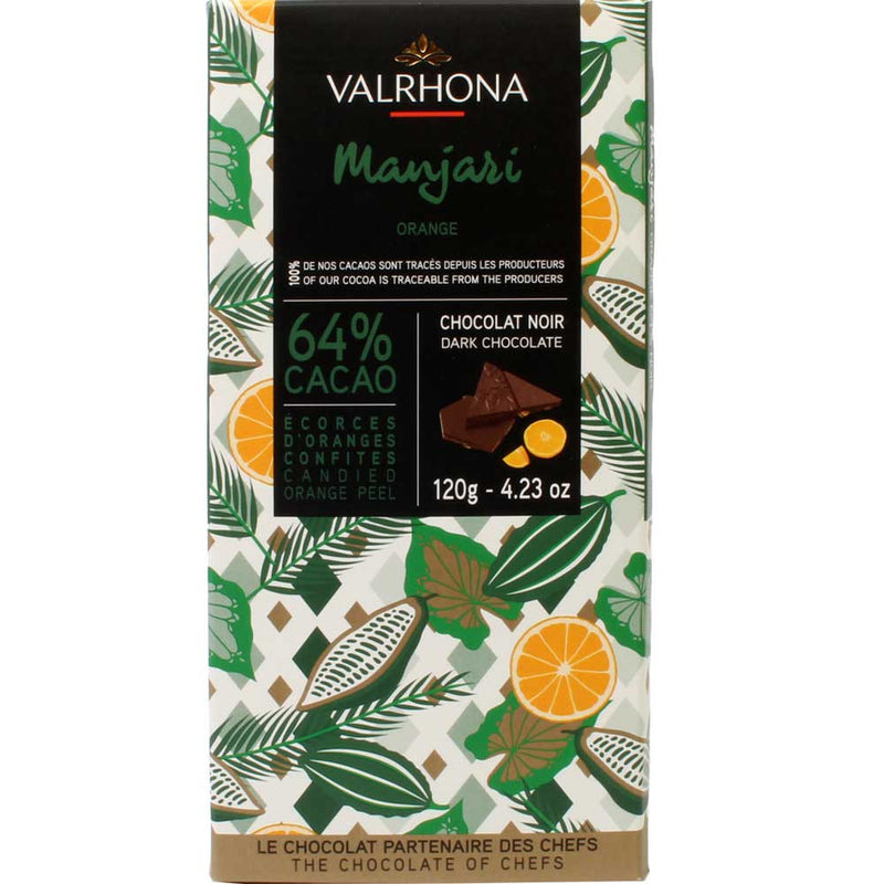A Valrhona Manjari Orange Peel 64% Bar 120g with oranges and leaves on it.